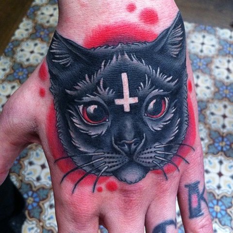 Готический кот с крестом на лбу на руке парня