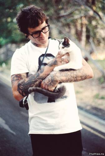 Парень в очках с тату на руках держит котика
