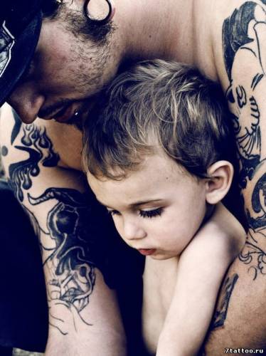 Мужчина со своим сыном с татуировками на руках