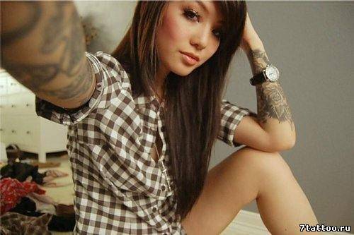 Девушка в клетчатой рубашке с татуировками на рука