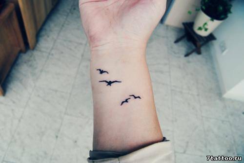 тату маленькие летящие птички на руке девушки