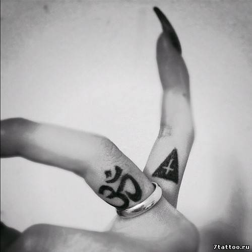 Иероглиф и крест в пирамиде на пальцах девушки
