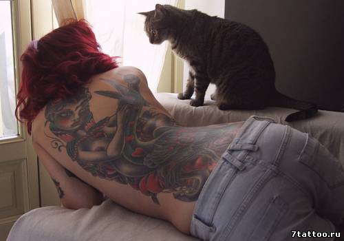 Девушка с тату на всю спину лежит рядом с котом